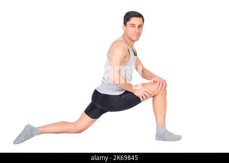 Positive sportsman doing stretching exercise in studio Stock Photo