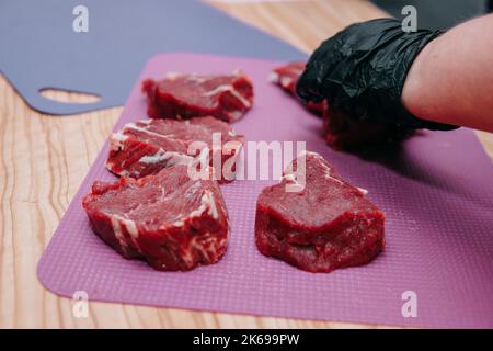 Preparation of raw meat roll. Cooking steaks and meat rolls in the cooking class. Sliced meat on a plate, close-up. Stock Photo