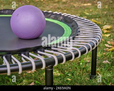 medicine ball on a mini trampoline for fitness exercising and rebounding in a backyard Stock Photo
