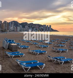Benidorm, Spain - 11 March, 2022: Sunloungers at Dawn on Benidorm beach Stock Photo