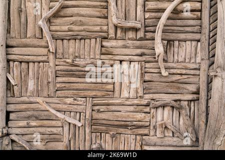 Rustic background pattern of weathered old wooden sticks and twigs on a wall Stock Photo