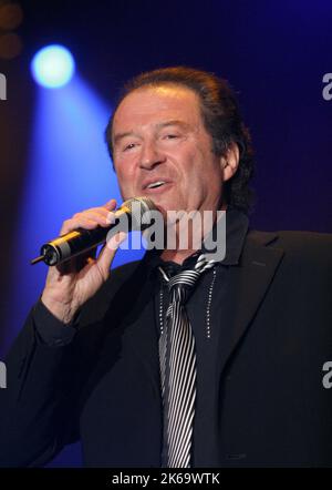 Singer Chris Andrews celebrates with pop singers Peter Petrell (C) and ...