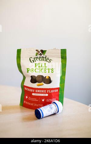 A package of Greenies' Pill Pockets, hickory smoke flavor, used to hide pills for pets in delicious flavored pockets of food. A vial of pills. Stock Photo