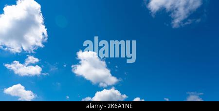 Bright luminous blue sky with scattered small white clouds Stock Photo