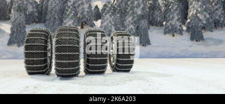 Four winter tires with snow chains on snow as panorama safety background Stock Photo