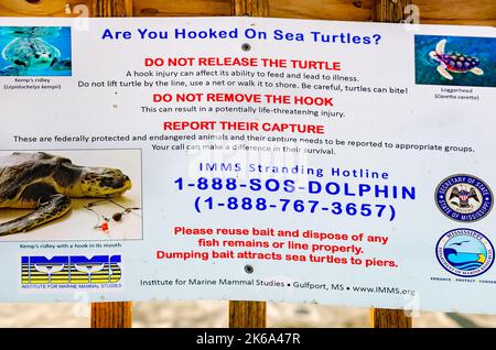 Signs tell anglers what to do if they catch a sea turtlealong the Pascagoula River at Lighthouse Park, Oct. 4, 2022, in Pascagoula, Mississippi. Stock Photo