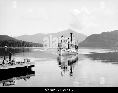 Steamboat Doris on Lake Placid against the backdrop of Adirondack Mountains, circa 1900. Stock Photo