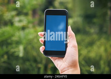 Digital, mockup and phone with woman in nature for internet, communication and app. Technology, social media and contact with hands of user and Stock Photo