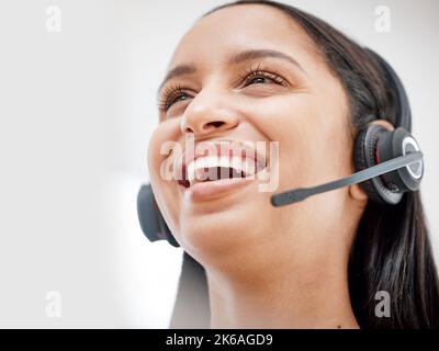 One young hispanic happy and cheerful female call center agent wearing a headset and working in customer service at work. Face of a hispanic woman Stock Photo