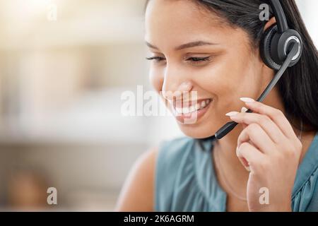 One young hispanic happy and cheerful female call center agent wearing a headset and working in customer service at work. Face of a hispanic woman Stock Photo