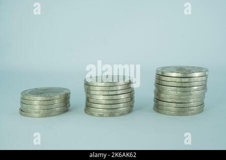 Thai baht coins stack isolated on blue background. Financial and saving concept. Stock Photo