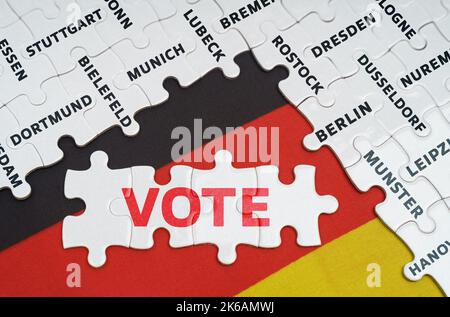 National concept. On the flag of Germany there are puzzles with the names of cities and puzzles with the inscription - Vote Stock Photo