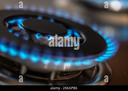 The gas burner burns with the blue flame of a propane butane stove in a home kitchen or hotel restaurant. Stock Photo