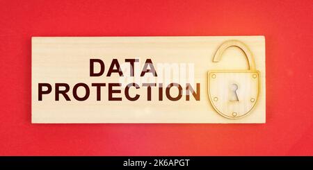 Business concept. On a red background there is a small plaque on it with a lock and an inscription - DATA PROTECTION Stock Photo
