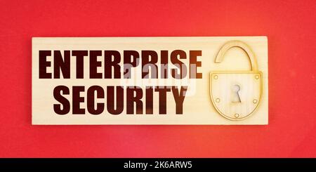 Business concept. On a red background there is a small plaque on it with a lock and an inscription - ENTERPRISE SECURITY Stock Photo