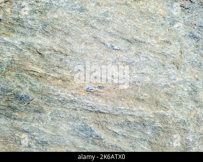 Grey stone background texture. Rocky formation, gray brown rough material. Abstract natural hard granite surface. Greek island Cyclades Greece. Stock Photo