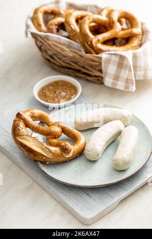 Traditional Bavarian white sausages on the plate and pretzes. Stock Photo