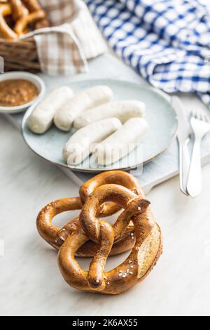 Traditional Bavarian white sausages on the plate and pretzes. Stock Photo