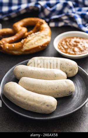 Traditional Bavarian white sausages on the plate and pretzes. Stock Photo