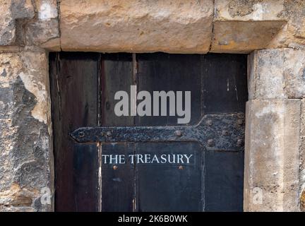 the treasury, old strong wooden door, safe door, solid secure door, antique oak door to the treasury, door with the treasury label on it. Stock Photo