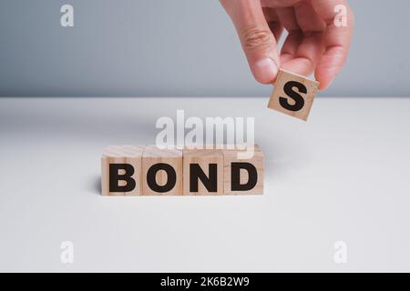 Concept of bonds. Businessman puts wooden blocks with the word Bonds. Equivalent loan. Unsecured and secured bonds. Bonds increasing concept. Copy spa Stock Photo