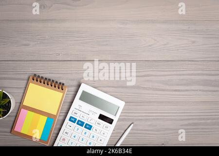 Calculator and open notepad close up on wooden desk Stock Photo