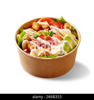 Caesar salad with lettuce, tomatoes, quail eggs, croutons and smoked salmon in cardboard bowl on white Stock Photo