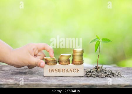 INSURANCE WORD Golden coin stacked with wooden bar Stock Photo