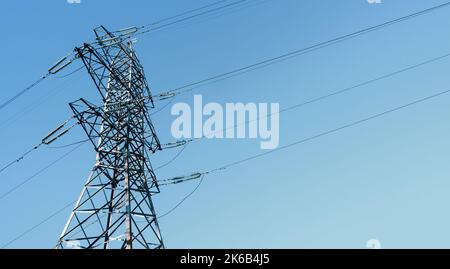 Steel power pylon construction with high voltage cables against blue sky. Stock Photo