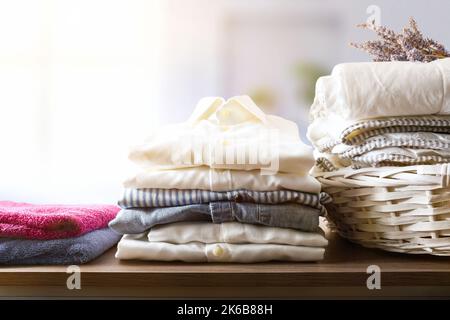 Clean clothes folded on a wooden shelf in a rooms on a wooden shelf in bedroom. Front view. Horizontal composition. Stock Photo