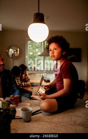 Boy controlling light through home automation system on smart phone Stock Photo