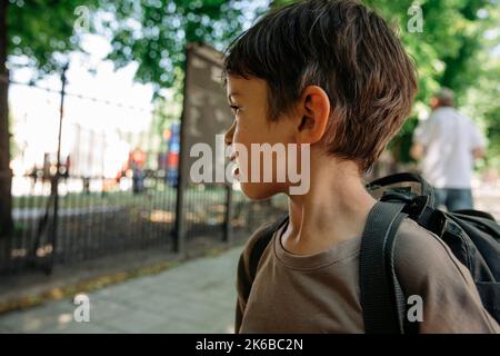 Thoughtful boy looking away wearing backpack Stock Photo