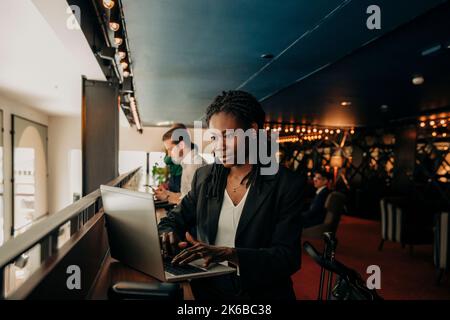 Young businesswoman using laptop while working in hotel lounge Stock Photo