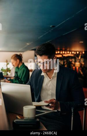 Serious businessman working on laptop in hotel lounge Stock Photo