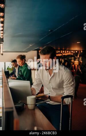 Young businessman using laptop while sitting in hotel Stock Photo