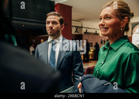Young businessman standing by smiling businesswoman in hotel lounge Stock Photo