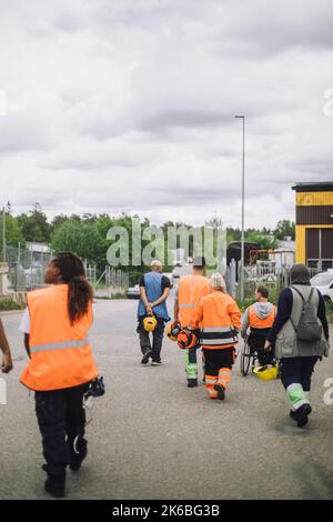 Male and female construction workers walking together on road Stock Photo