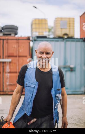 Happy bald construction worker walking at site Stock Photo