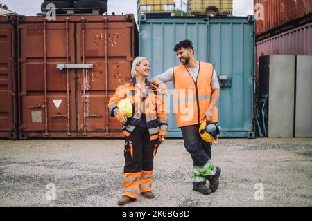 Full length of happy male and female colleagues looking at each other at construction site Stock Photo