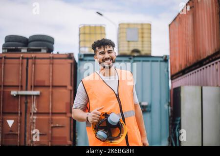 Portrait of happy young construction worker with hardhat at site Stock Photo