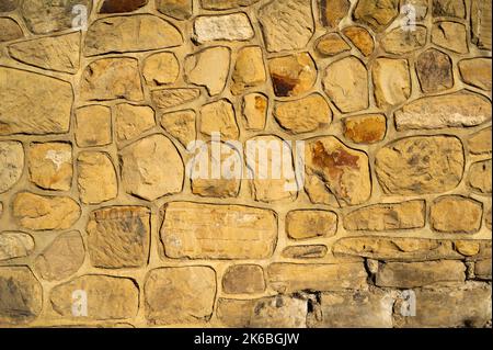 Natural Sandstone Stone Wall Texture Background with Fresh Mortar. Different Sized Uncut Large Stones Stock Photo