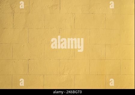 Yellow Painted Plaster Wall from 1850s with Lines Simulating Large Stone Bricks Stock Photo