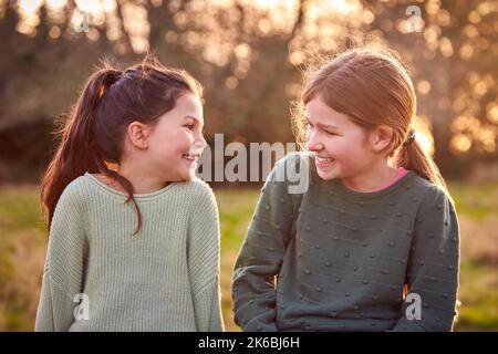 Portrait Of Two Girls Outdoors Laughing And Talking Together Stock Photo