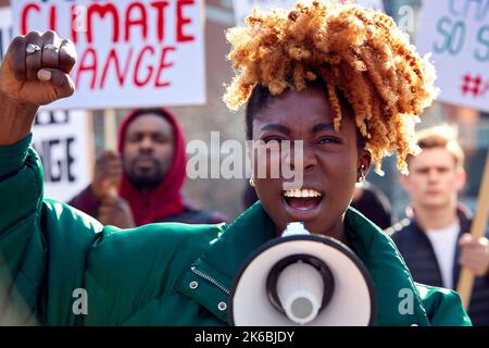 Group Of Protestors With Placards And Megaphone On Demonstration March Against Climate Chane Stock Photo