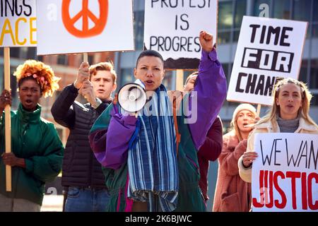 Group Of Protestors With Placards And Megaphone On Anti War Demonstration March Stock Photo