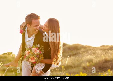 Romantic Married Couple Celebrating Beach Wedding With Groom Giving Bride In Dunes Piggyback Stock Photo