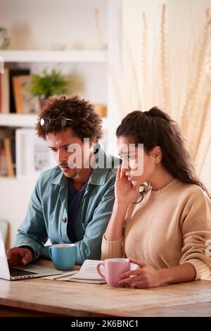 Worried Young Couple In Debt At Home With Laptop Reviewing Domestic Finances Together Stock Photo