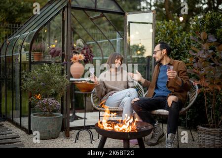 Young couple have a dinner by the fire at backyard Stock Photo