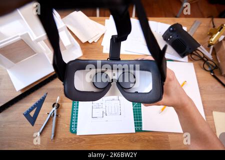 POV Shot Of Female Architect With Virtual Reality Headset Working In Office On Plans For Building Stock Photo