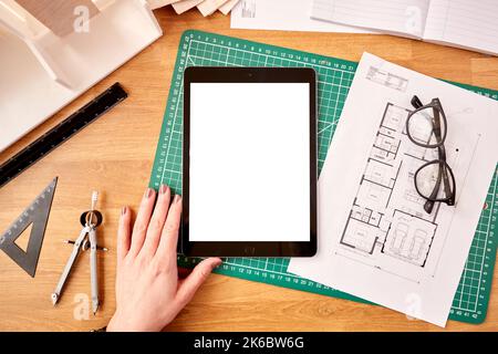 POV Shot Of Female Architect Working In Office On Plans For New Building Using Digital Tablet Stock Photo